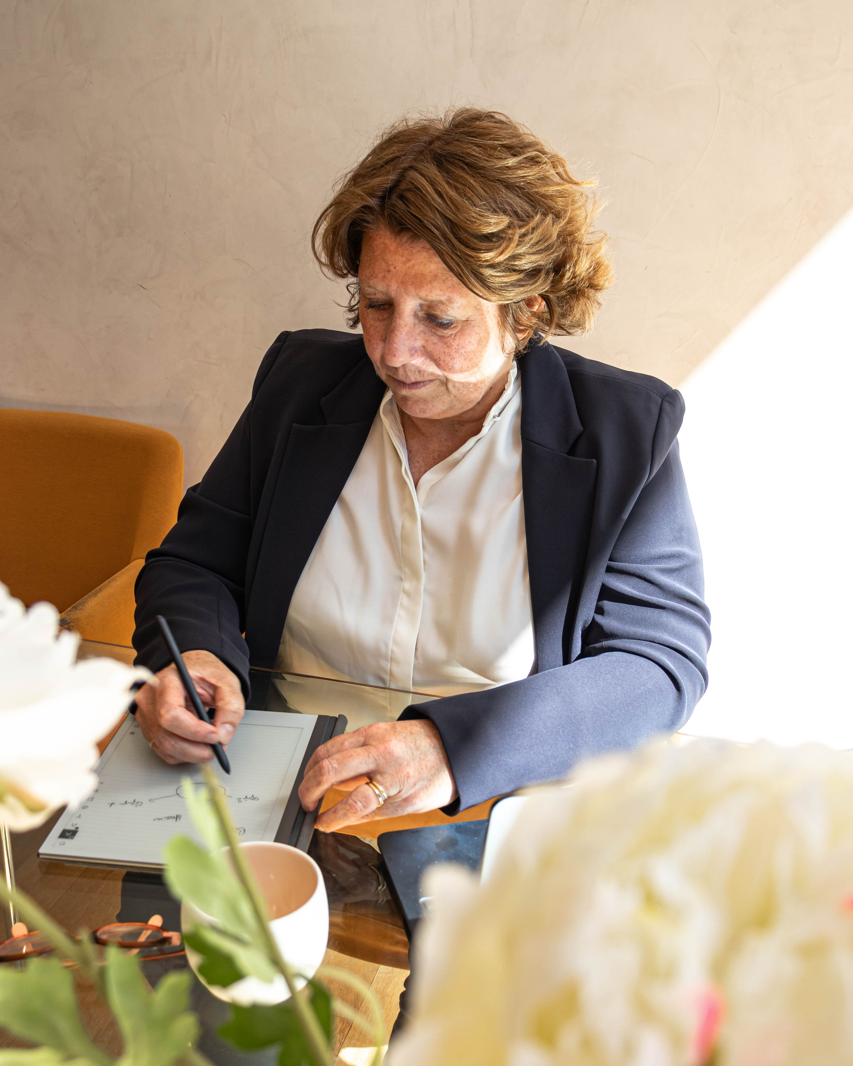 Violaine Herriau au travail, prenant des notes sur tablette dans son bureau